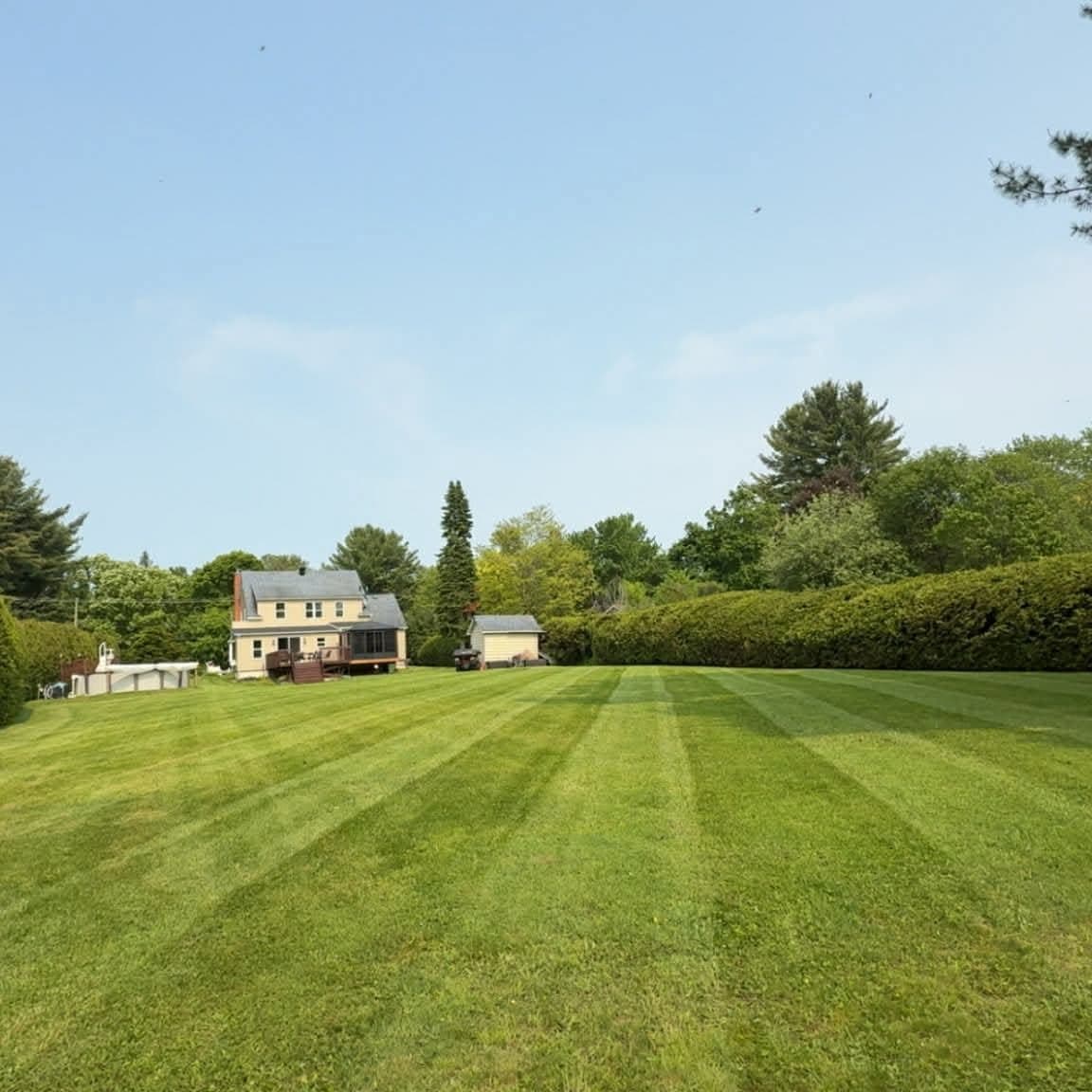 Striped lawn with a house in the distance